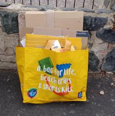 Flattened cardboard in a yellow shopping bag for life