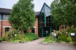 The front of the Whitwick Business Centre building with trees either side of the main entrance.